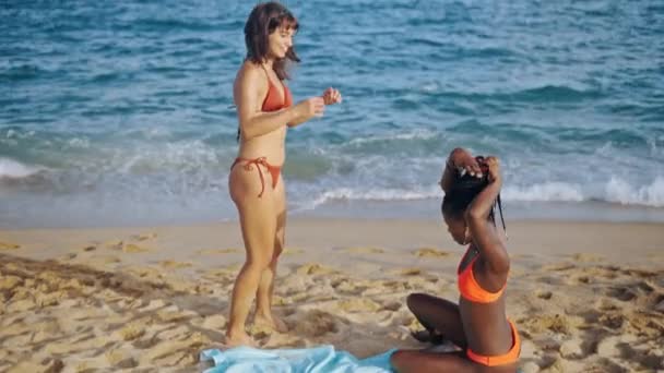 Две молодые женщины разных рас на летнем побережье — стоковое видео