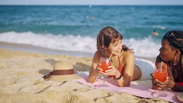Due ragazze allegre in costume da bagno sdraiato sulla spiaggia di sabbia — Video Stock