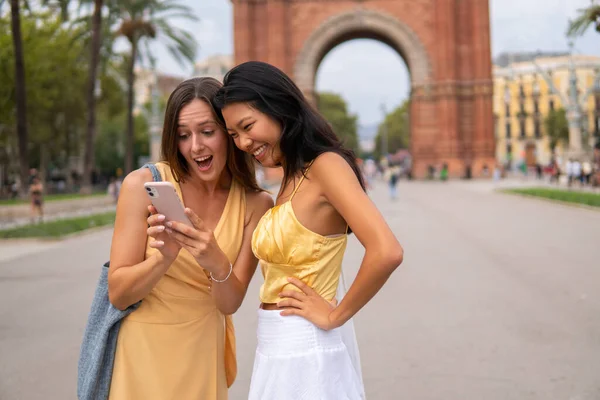 Emocionado diversas namoradas usando smartphone na cidade — Fotografia de Stock