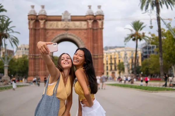Elegantes viajeros femeninos tomando selfie en la ciudad — Foto de Stock