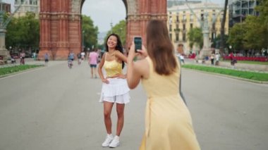 Şık bayan turistler şehirde fotoğraf çekiyorlar.
