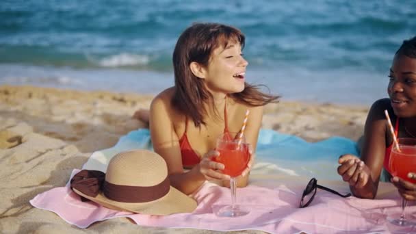 Две очаровательные девушки загорают на пляже — стоковое видео