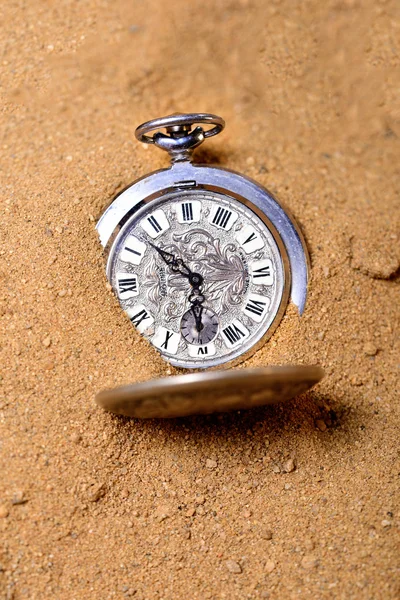 Vecchio orologio da tasca adagiato sulla sabbia — Foto Stock