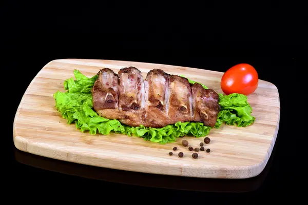 Sabrosas costillas a la parrilla en una hoja de lechuga — Foto de Stock