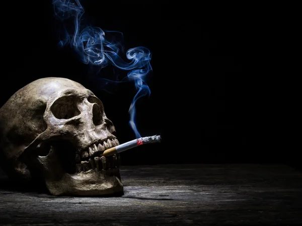 Stillleben Totenkopf und Zigarette Menschen rauchen Zigarette und erhalten zu — Stockfoto