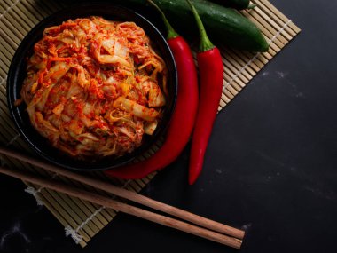 Kore yemeği, siyah tabakta lahana turşusu koyu arka planda..