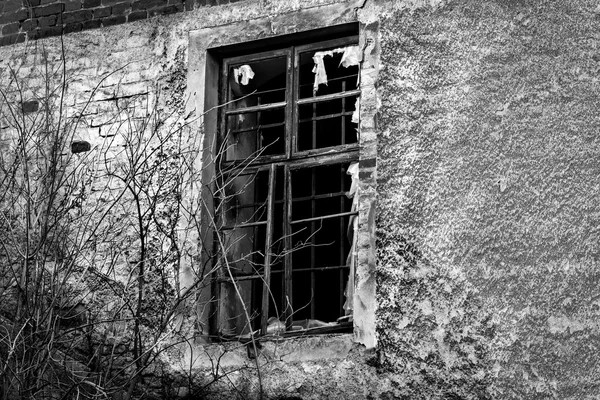 Vieux mur noir et blanc endommagé avec une fenêtre barrée — Photo