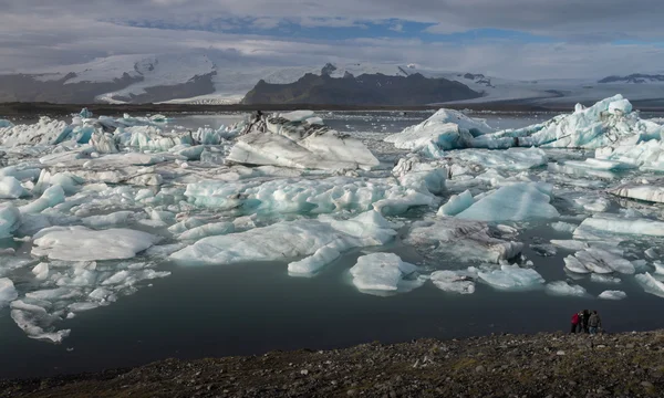 Cubo di ghiaccio nella laguna glaciale di Jokulsarlon con sfondo di montagna innevata — Foto Stock