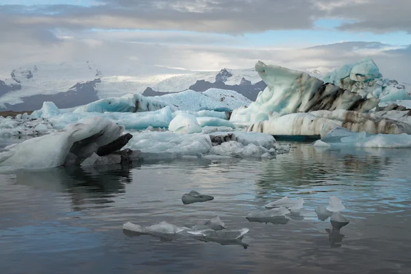 Ice cubes at  Jokulsarlon Glacier Lagoon with snow mountain background — Stock Photo, Image