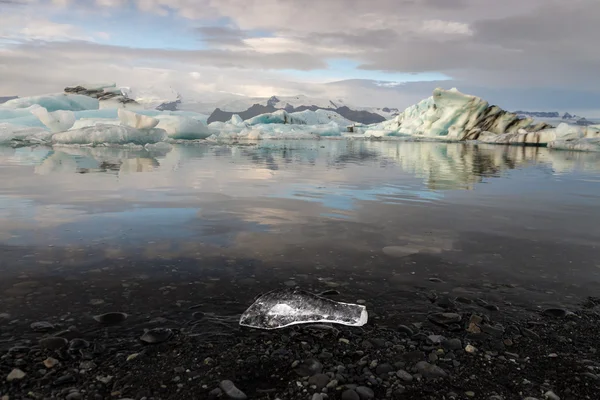 Fekete kavics és kis ice cube előtér Jokulsarlon gleccser lagúna jégkockát tükre alatt napkelte Jogdíjmentes Stock Fotók