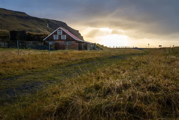 Maison de campagne entourée d'herbe jaune pendant l'heure du lever du soleil sur la saison d'automne — Photo