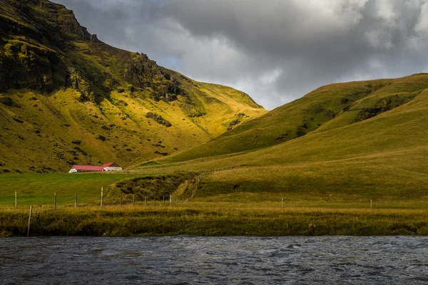 Ferme entourer champ vert avec rivière au premier plan et fond de chaîne de montagnes en saison d'automne — Photo