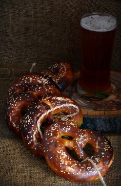 Karanlık bir arka plan üzerinde bira ile Alman simit