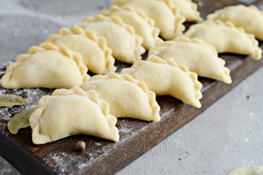 Mavi arka planda patatesli hamur tatlısı. Varenyky, vareniki, pierogi, pyrohy - dolgulu hamur tatlısı.