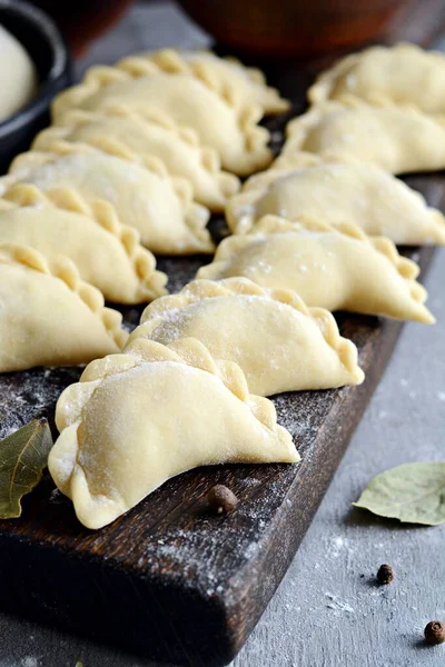 Mavi arka planda patatesli hamur tatlısı. Varenyky, vareniki, pierogi, pyrohy - dolgulu hamur tatlısı.