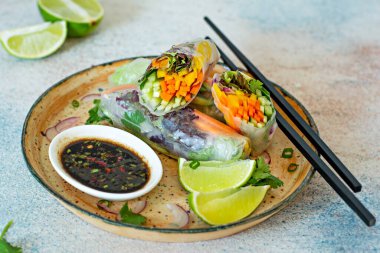 Pirinç kağıdı, çiğ sebze ve açık mavi arka planda acı soslu bitkilerden yapılmış taze Asya aperatifli börekler (Nem). Vietnam Yemekleri