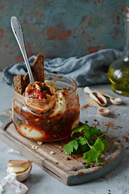 Baharatlı domates soslu haşlanmış yumurta. Baharatlı aperatif. Zeytinyağında haşlanmış yumurta, domates sosu, kavanozda kırmızı biber, taze maydanoz ve sarımsak..