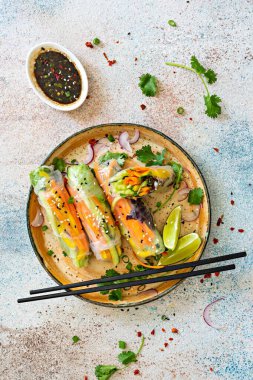 Pirinç kağıdı, çiğ sebze ve açık mavi arka planda acı soslu bitkilerden yapılmış taze Asya aperatifli börekler (Nem). Vietnam Yemekleri