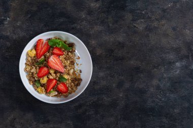 Ev yapımı gevrek, fındık, kurutulmuş meyve, taze çilek, nane ve yoğurt, mayalanmış süt. Sağlıklı kahvaltı kavramı.