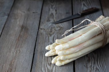 Ahşap arka planda çiğ beyaz kuşkonmaz. Sağlıklı gıda konsepti, fotokopi alanı. Sebze lif bakımından zengindir, doğal bir prebiyotiktir..