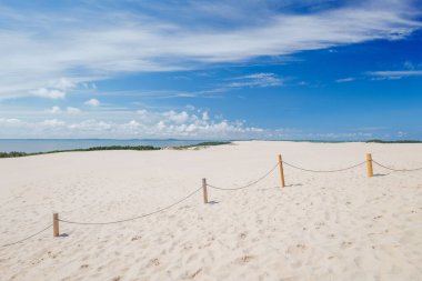 Güzel manzara. Kum tepeleri. Lebsko Gölü ve Baltık Denizi manzarası. Ahşap direkler ve iplerden yapılmış bir çit. Leba, Polonya. Slowinski Ulusal Parkı.