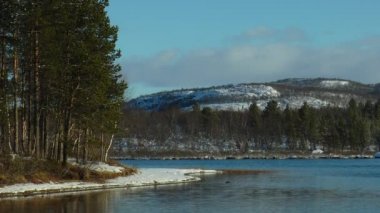 İlk sonbahar karla kaplı gölün kıyısında.