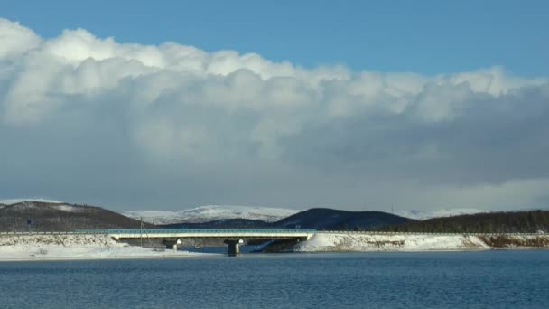 Movimento rápido Norte do outono nuvens baixas sobre o lago e a ponte, timelapse . — Vídeo de Stock