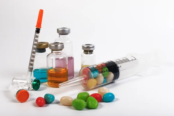 Uma seringa e um frasco de doces isolados sobre fundo branco. Proteger contra diabetes . — Fotografia de Stock