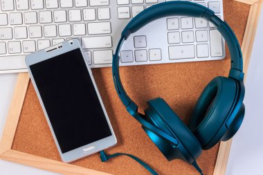 Kulaklıklar, cep telefonu ve zanaat tahta üzerinde klavye.