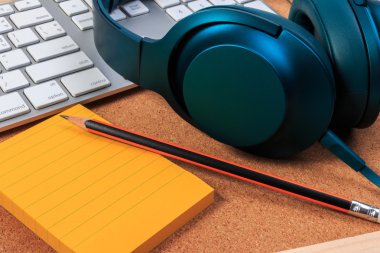 Kulaklık, klavye, kağıt Not ve zanaat tahta üzerinde kalem.