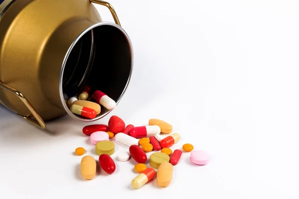 Capsule e pillole in un flacone di caramelle aperto sul tavolo isolato su bianco. Proteggere contro il diabete . — Foto Stock