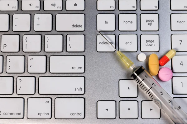 Pillole capsula e siringa sulla tastiera del computer, concetto di medicina lavoro duro e assistenza sanitaria . — Foto Stock