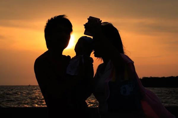 Familia feliz tomando selfie en la playa durante el día . —  Fotos de Stock