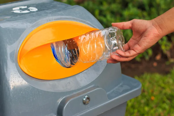 Hombre poniendo botella de plástico vacía en la papelera pública de reciclaje . —  Fotos de Stock