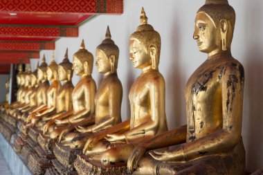 Tayland kamu tapınakta altın Buddha heykeli. Buda imanges farklı duruş içinde satır.