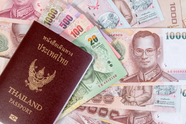 Passaporte tailandês com nota de dinheiro tailandesa em fundo monetário tailandês. O passaporte do cidadão tailandês na nota tailandesa . — Fotografia de Stock