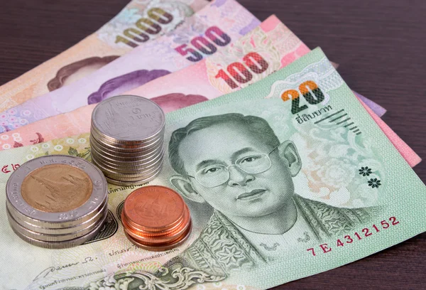 Thais geld: Close-up van bankbiljetten en munten. Thailand papiergeld en munten op houten tafel. — Stockfoto