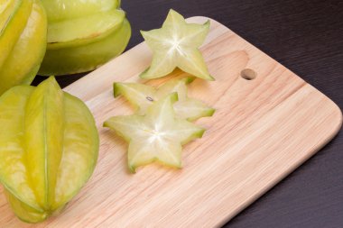 Ahşap blok üzerinde yıldız elma ve averrhoa carambola. Ahşap masada taze yıldız elma meyvesi.