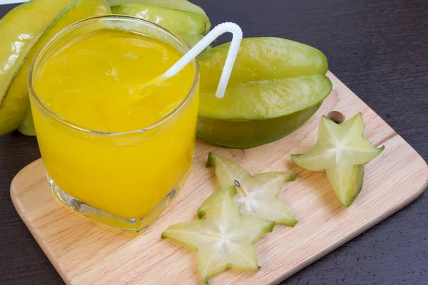 Sumo de maçã estrela ou abóbora averrhoa carambola no bloco de madeira. Sumo de maçã estrela fresca na mesa de madeira . — Fotografia de Stock