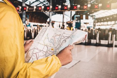 Brighton, İngiltere - 23 Ekim 2019: Londra 'ya giden yolu bulmak için Brighton Tren İstasyonu önünde Londra haritasını elinde tutan genç adam.