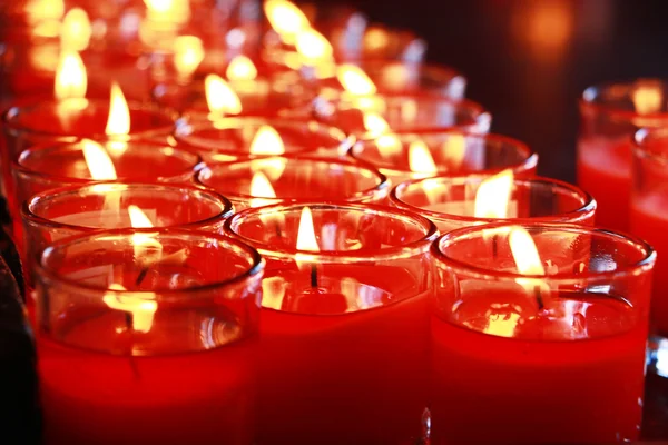 Muitas velas vermelhas queimando no interior do templo budista — Fotografia de Stock