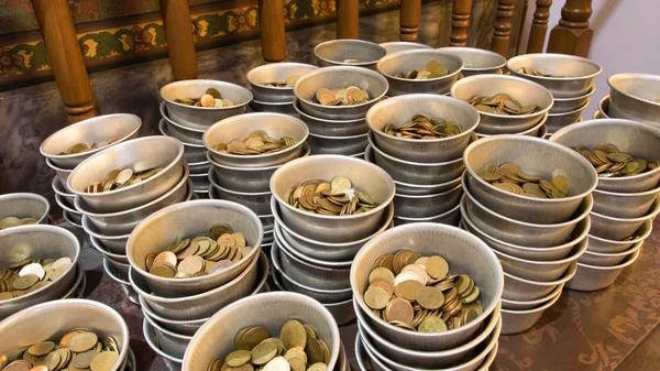 Moneda en el cuenco de donación y moneda de bronce — Foto de Stock