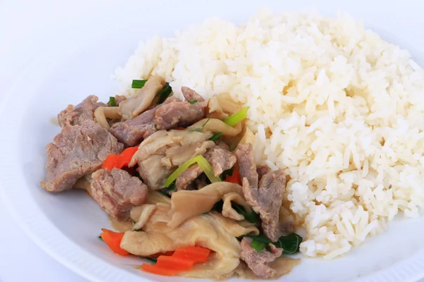 Tay tarzı pilav ve kızarmış istiridye sosu ile beyaz tabak üzerinde izole sığır eti