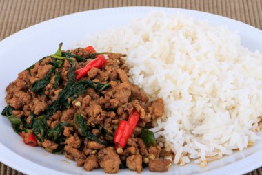 Tay tavada kızartılmış domuz eti ve fesleğen hizmet ile pirinç.