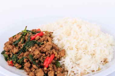 Tay tavada kızartılmış domuz eti ve fesleğen hizmet ile pirinç.