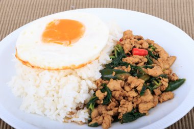 Tavada kızartılmış tavuk, fesleğen ve beyaz zemin üzerine kızarmış yumurta ile tepesinde pirinç