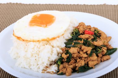 Tavada kızartılmış tavuk, fesleğen ve beyaz zemin üzerine kızarmış yumurta ile tepesinde pirinç