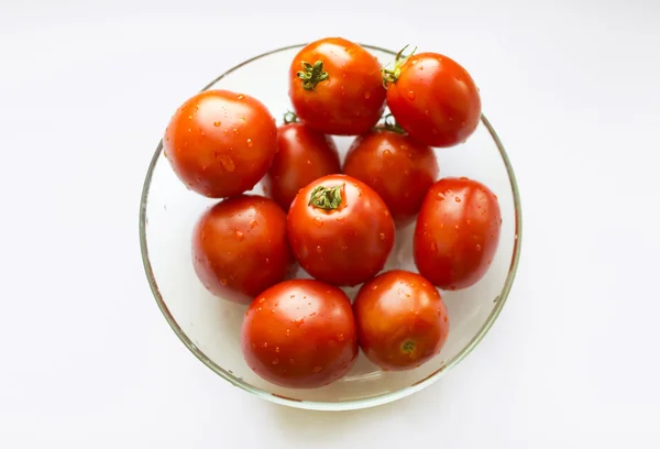 Красные помидоры в стеклянной чаше на белом фоне, вид сверху . — стоковое фото
