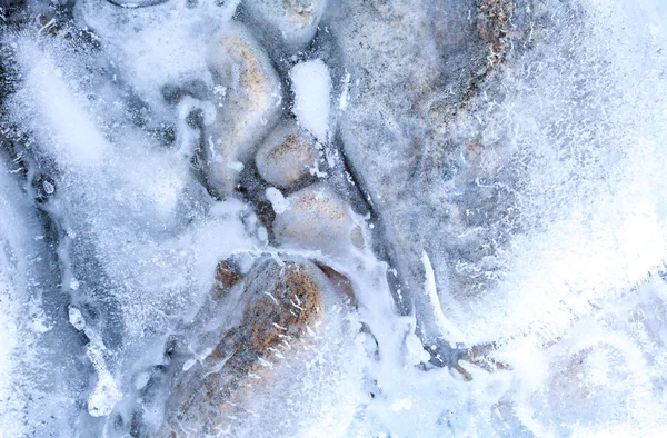 Прозорий лід з повітряними бульбашками і камінням — стокове фото