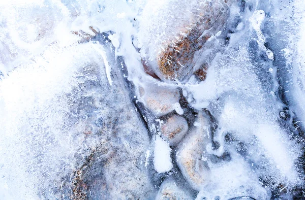 Прозорий лід з повітряними бульбашками і камінням — стокове фото